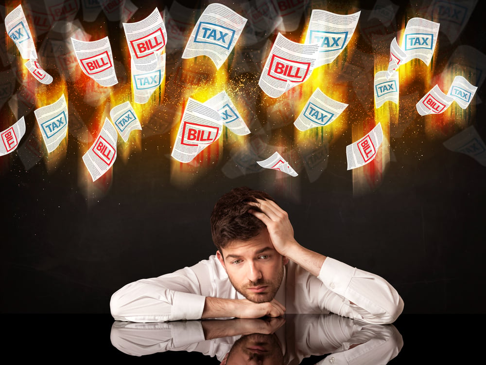 Depressed businessman sitting under falling papers